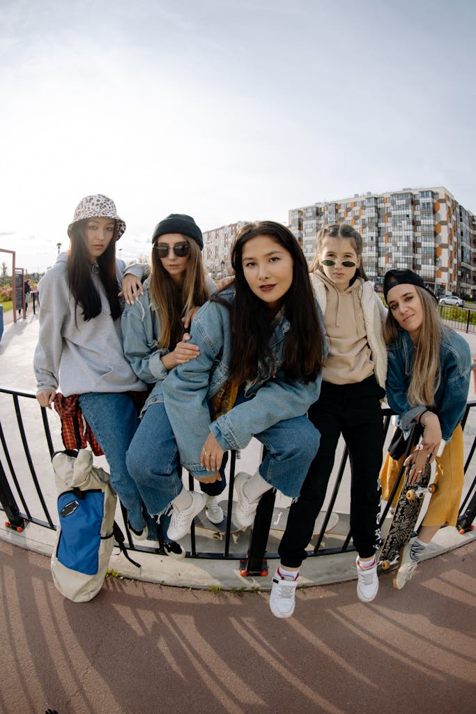 Group of teenage girls posing together with skateboards in an outdoor urban setting.