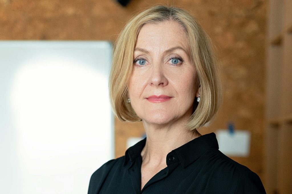 Confident mature businesswoman in office attire posing confidently indoors.